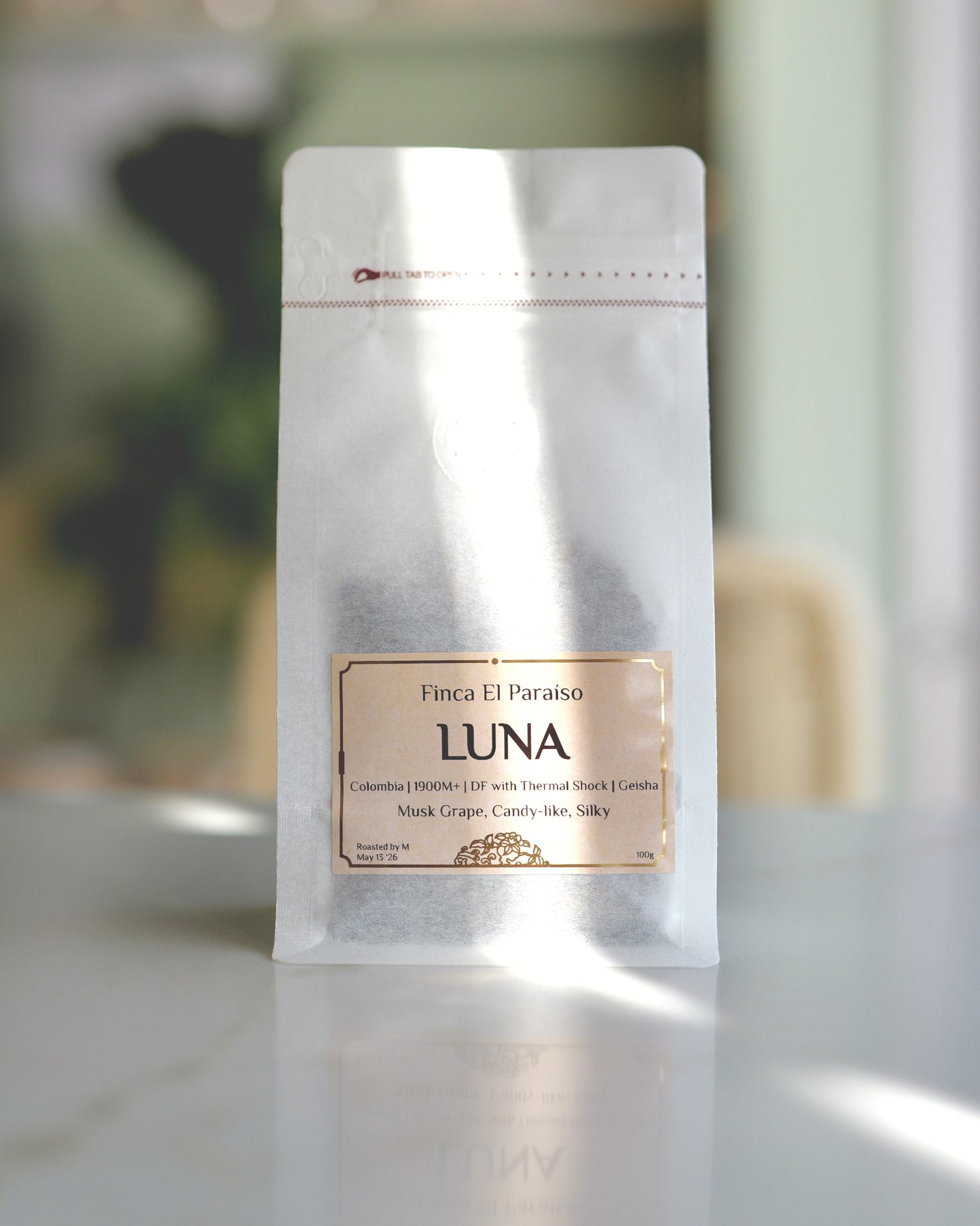 Luna coffee research release, whole bean bag, labeled 'LUNA' and  'Finca El Paraíso' on a blurred background