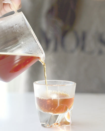 Luna research release coffee, poured into a clear glass cup on a marble surface